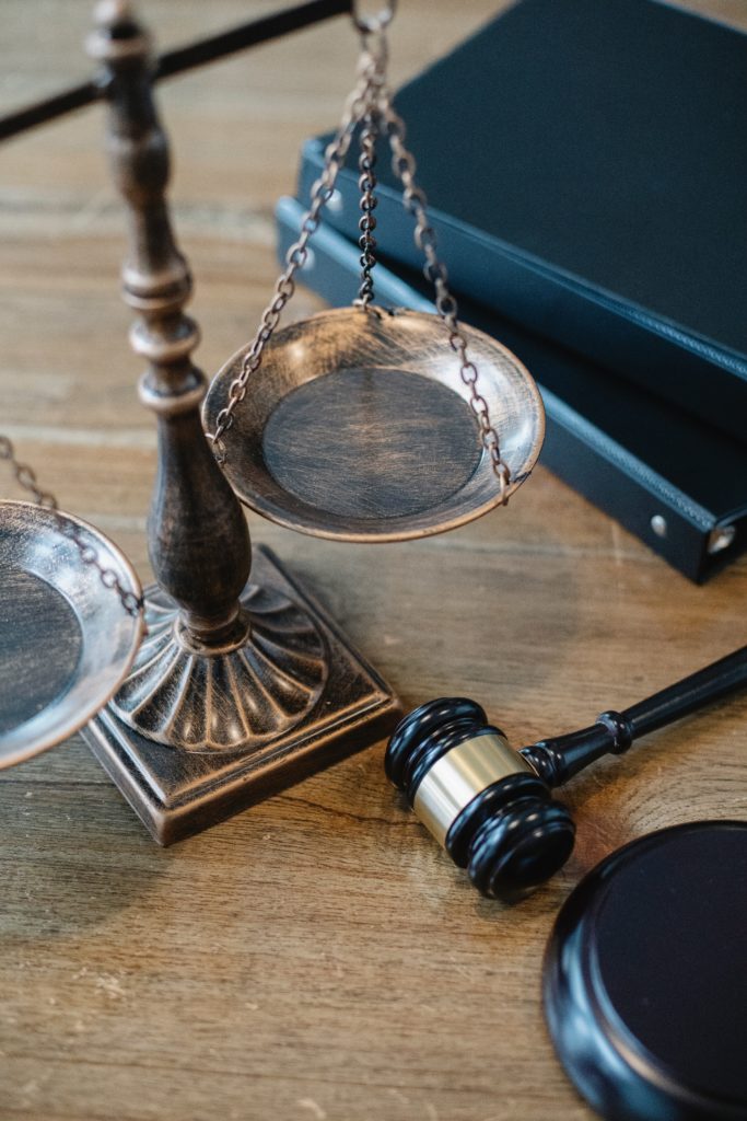 Image of a judge's gavel and scales on a wood table
