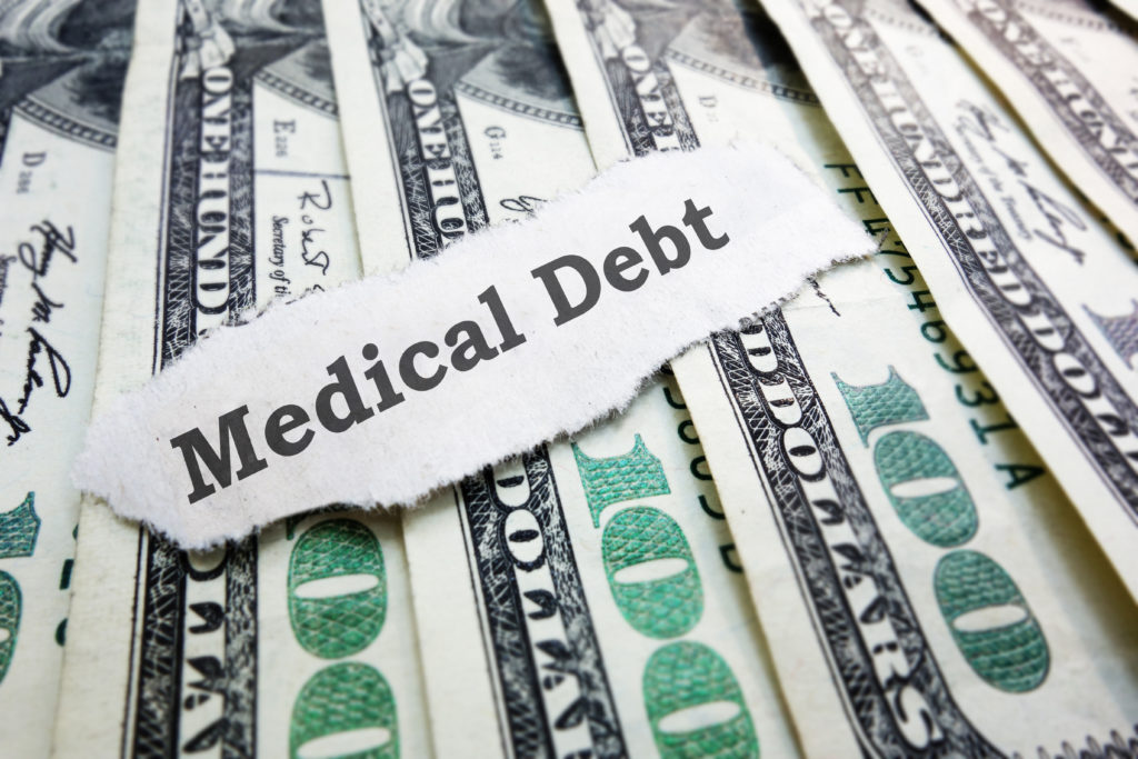 Medical Debt message on paper with hundred dollar bills