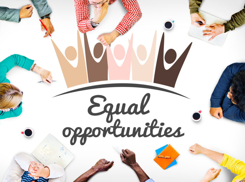 photo of various people of multiple genders and races sitting around a table as viewed from above.  The words "equal opportunity" is written in script in the center.