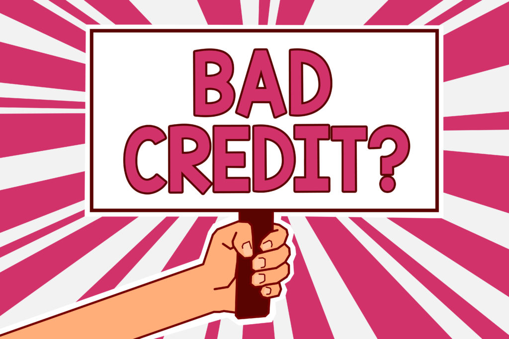 hand holding a poster with the words bad credit against a pink and white background