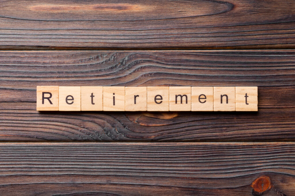 word retirement spelled in wooden tiles placed on a dark wood table