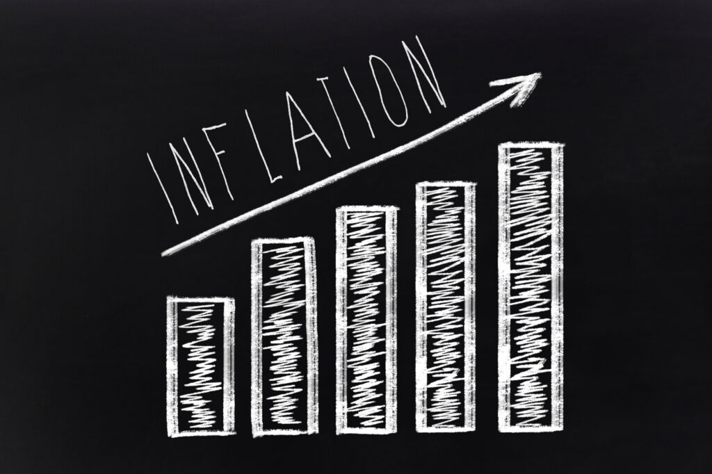 black background with an unlabeled bar graph trending upward and the word inflation written in white above it