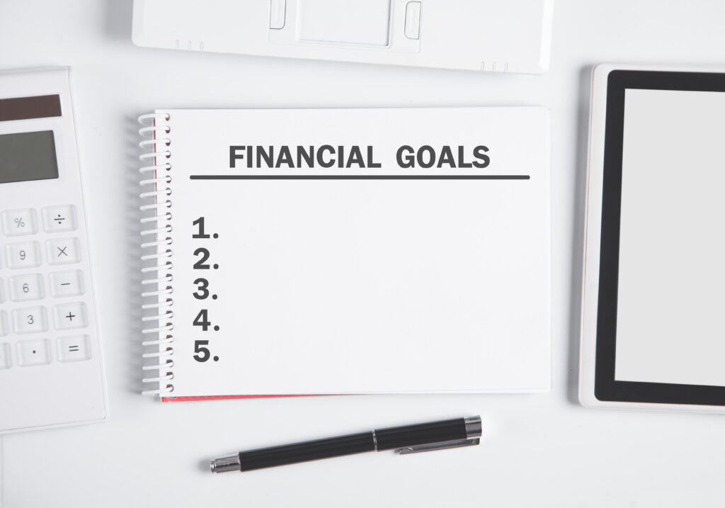 Notepad with the heading Financial goals listed at the top.  Under the heading is a blank numbered list from 1 to 5.  
